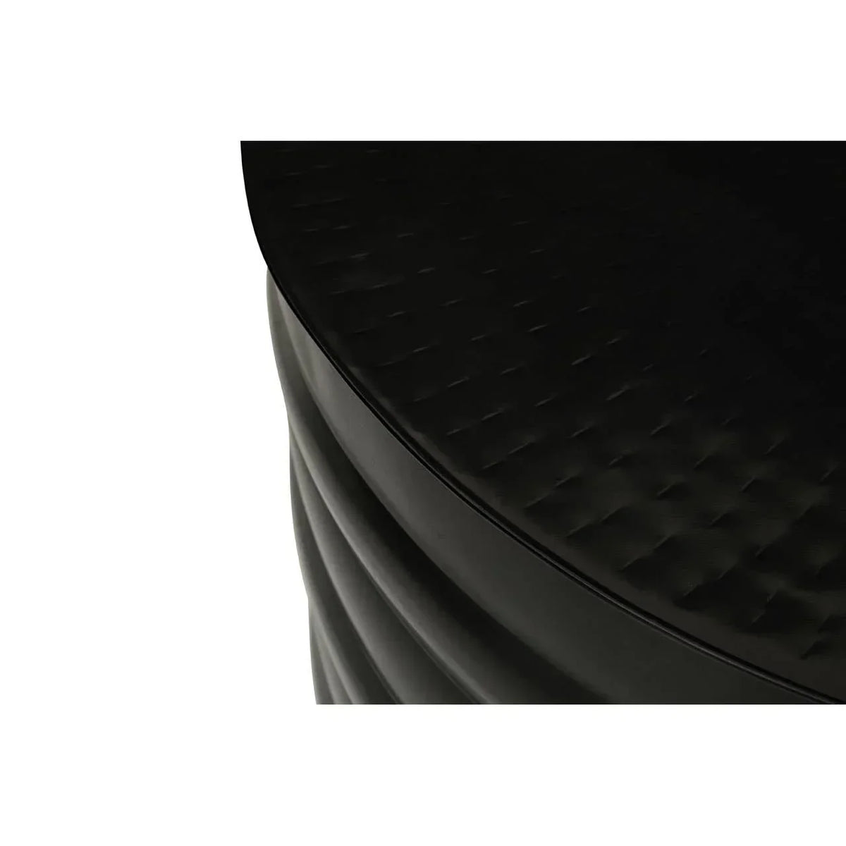 Black round side table with textured top and ribbed base, close-up of surface details