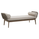 Beige cushioned daybed with wooden frame and round bolster pillows, rattan sides