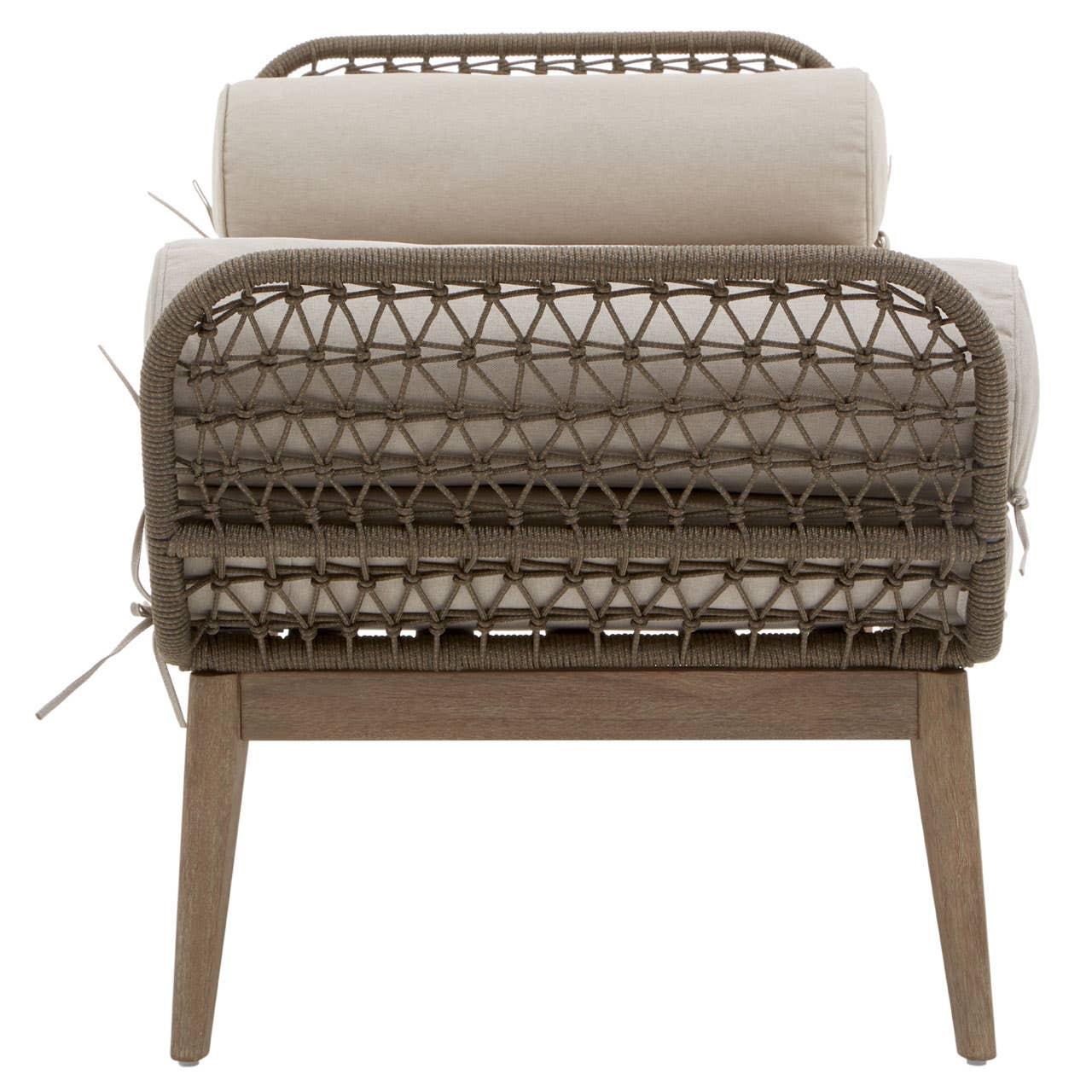 Rattan armchair with beige cushions shown from the back, wooden legs visible