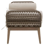 Rattan armchair with beige cushions shown from the back, wooden legs visible