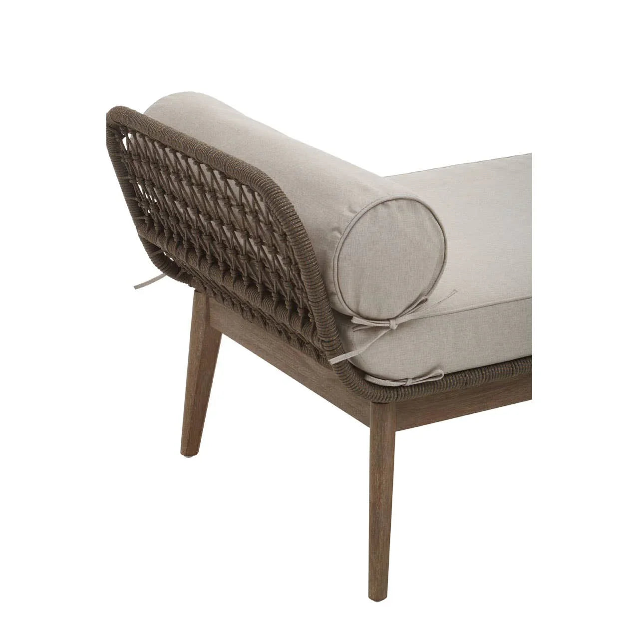 Corner view of rattan armchair with grey cushion and bolster pillow on wooden legs