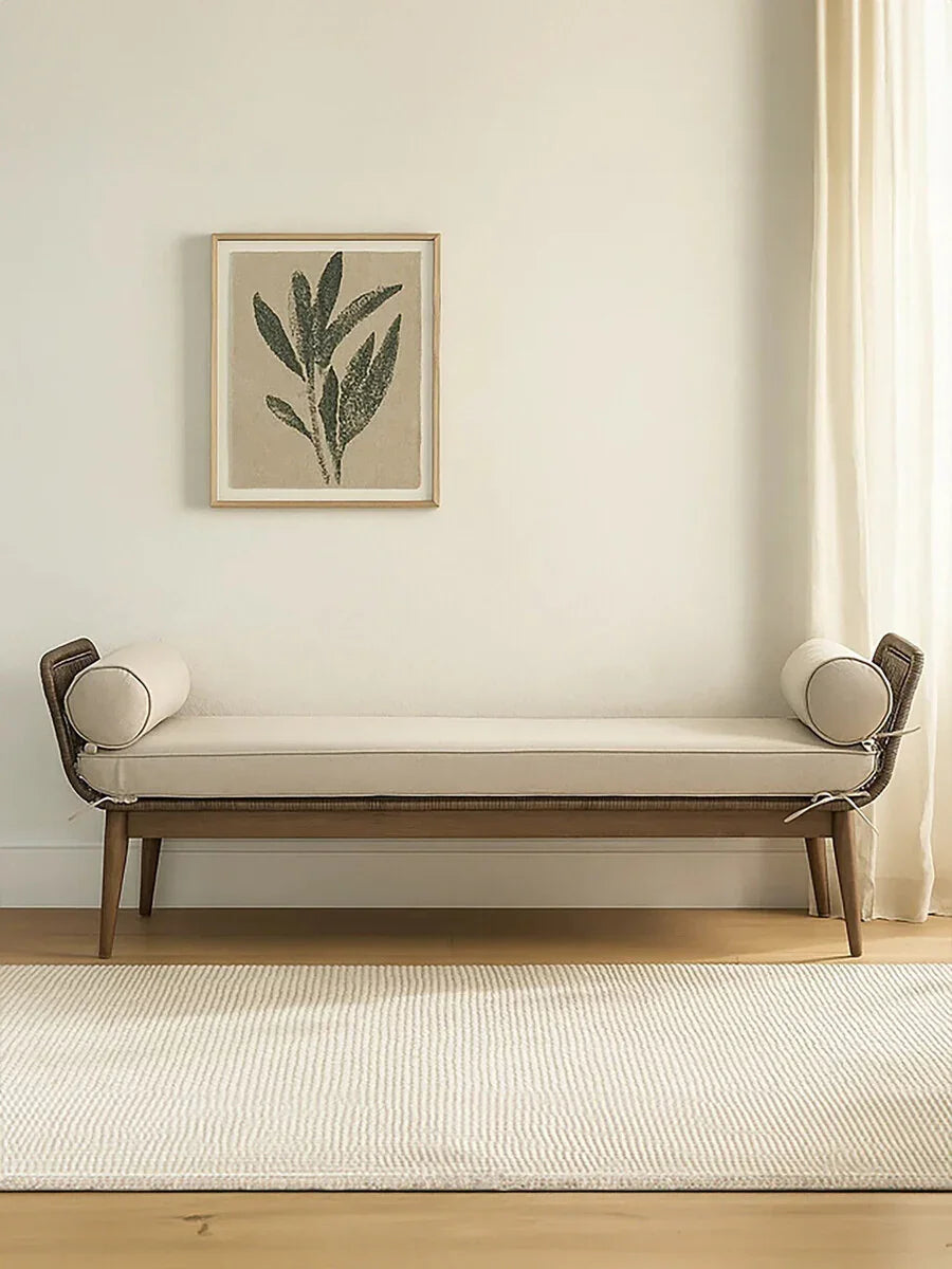 Beige upholstered bench with bolster cushions on wooden legs in minimalist living room