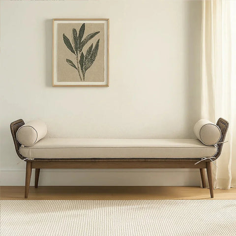 Beige upholstered bench with bolster cushions and wooden legs in a minimalist living room