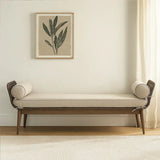 Beige upholstered bench with bolster cushions and wooden legs in a minimalist living room