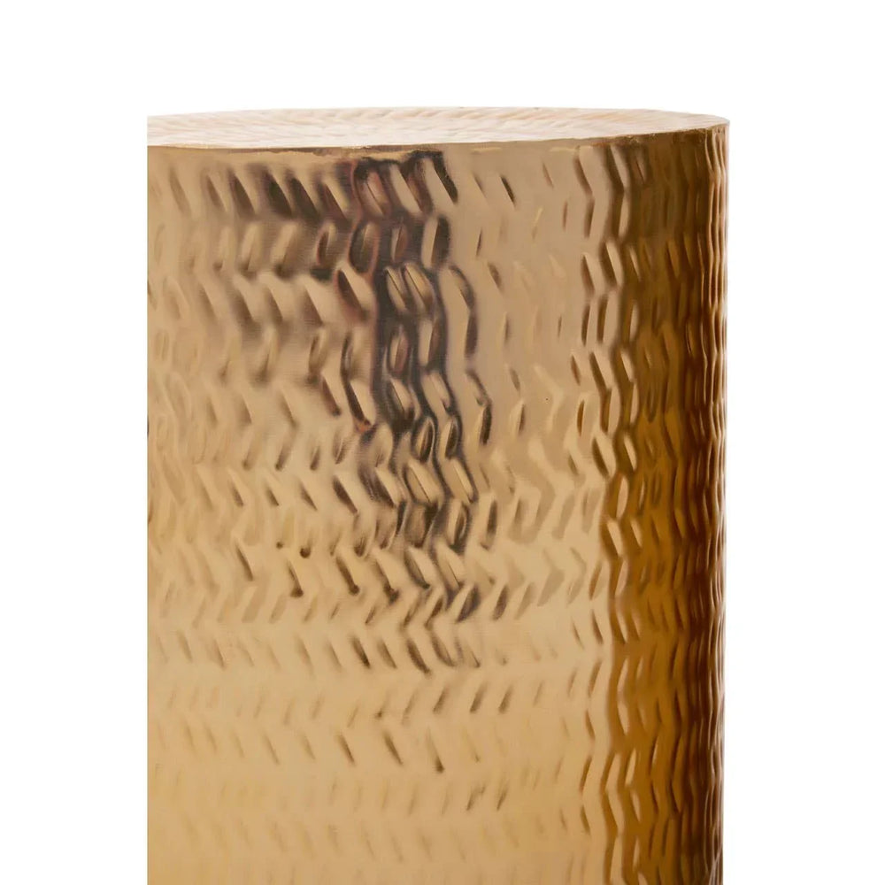 Close-up of gold hammered metal side table surface with textured pattern