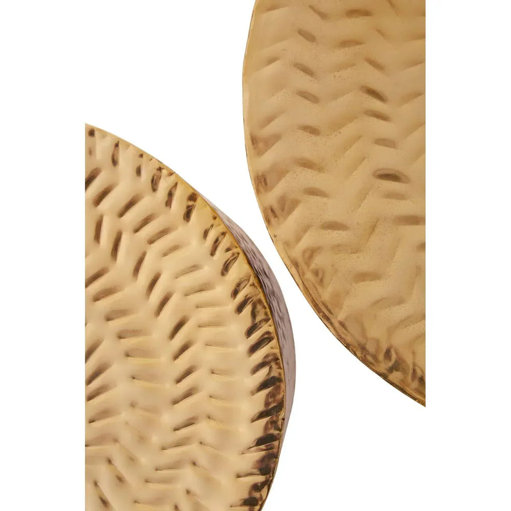 Closeup of round gold hammered metal table tops with textured surface detail