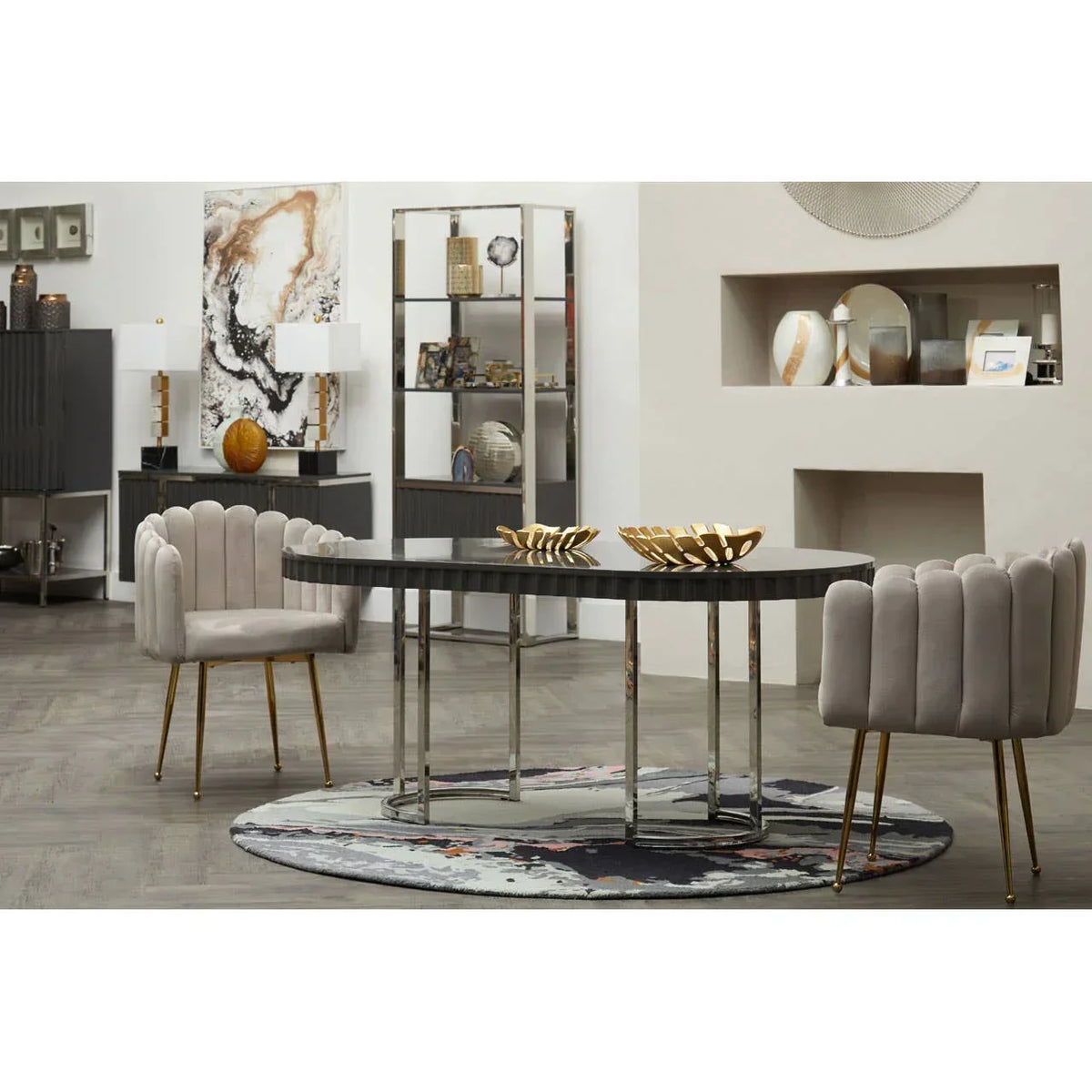 Modern dining table with black top and chrome legs, velvet chairs, and gold decor bowls