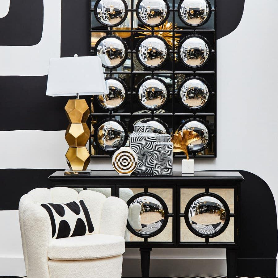 Modern mirrored sideboard with geometric accents, cream accent chair, gold table lamp
