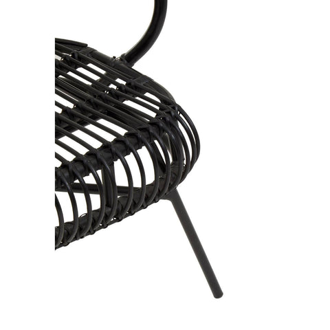 A close-up view of the Java Black Natural Rattan and Black Metal Scalloped Back Chair, showcasing the intricate rattan weaving and the sleek black metal frame. The scalloped back design is visible, highlighting the chair's modern aesthetic. One of the chair's legs is partially visible, emphasizing its sturdy construction