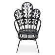 A black rattan chair featuring a scalloped back design with intricate leaf patterns, supported by slender metal legs. The chair has a wide seat and a stylish, open silhouette, suitable for indoor or outdoor use