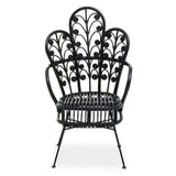 A black rattan chair featuring a scalloped back design with intricate leaf patterns, supported by slender metal legs. The chair has a wide seat and a stylish, open silhouette, suitable for indoor or outdoor use