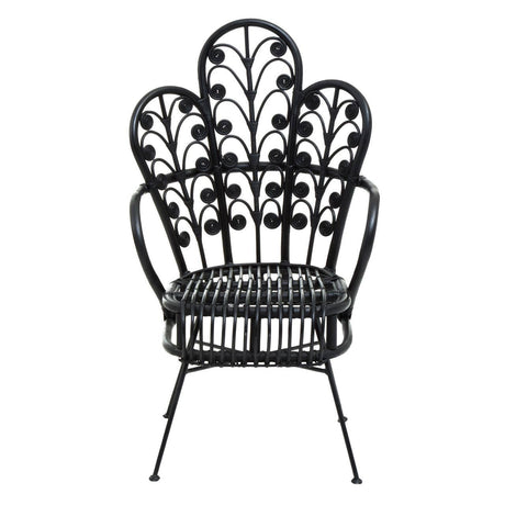 A black rattan chair with a scalloped back design featuring intricate leaf patterns, supported by slender metal legs. The chair has a wide seat and a distinctive, artistic silhouette that adds a stylish touch to any space