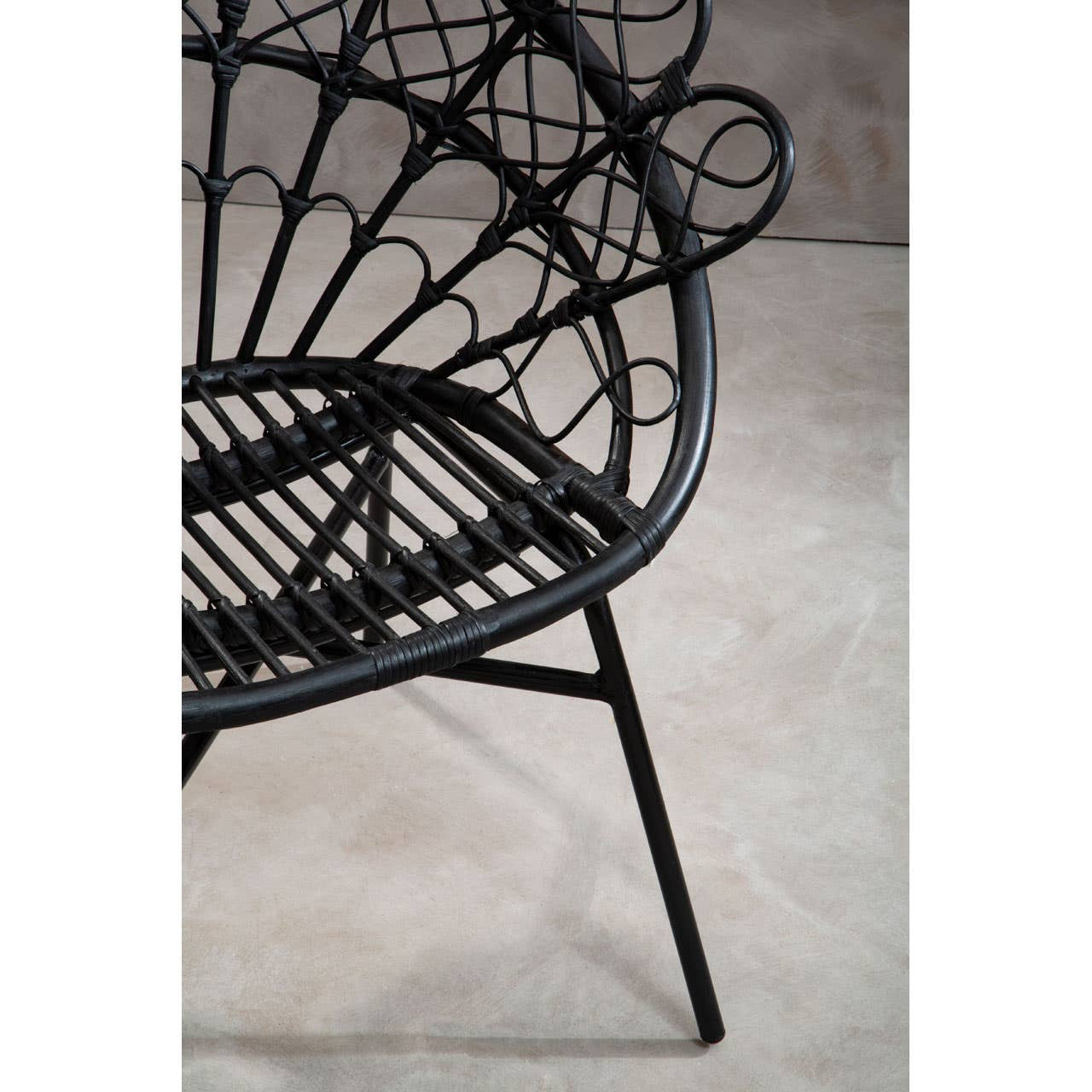 Black natural rattan peacock chair featuring a circular, fan-like backrest and a sturdy metal frame with angled legs, set against a neutral background
