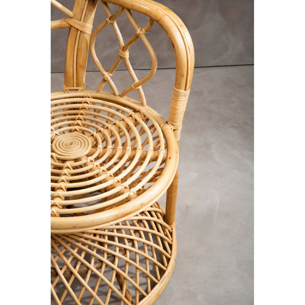 Curved chair made of natural rattan with a woven seat and backrest, showcasing intricate patterns and a light brown finish, set against a neutral background