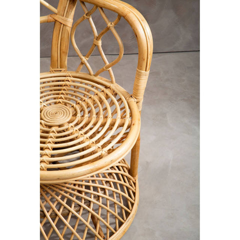 Curved chair made of natural rattan with a woven seat and backrest, showcasing intricate patterns and a light brown finish, set against a neutral background