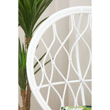 Curved chair made of natural rattan featuring a grey and white color scheme, showcasing a geometric pattern in the backrest. A green plant is partially visible in the background, adding a touch of nature to the setting