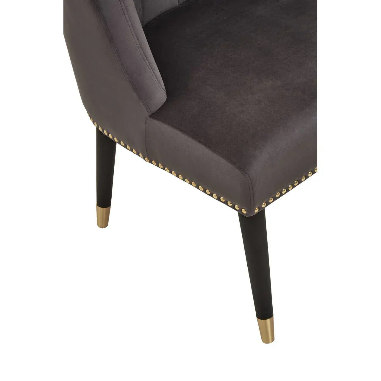 Grey velvet dining chair with gold stud trim and black tapered legs with gold caps