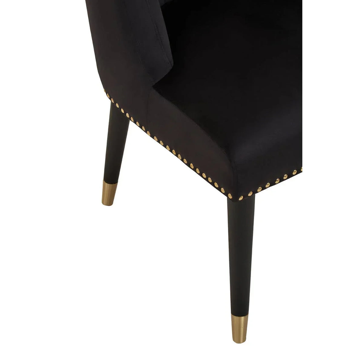 Black upholstered dining chair with gold stud detail and gold-tipped tapered legs