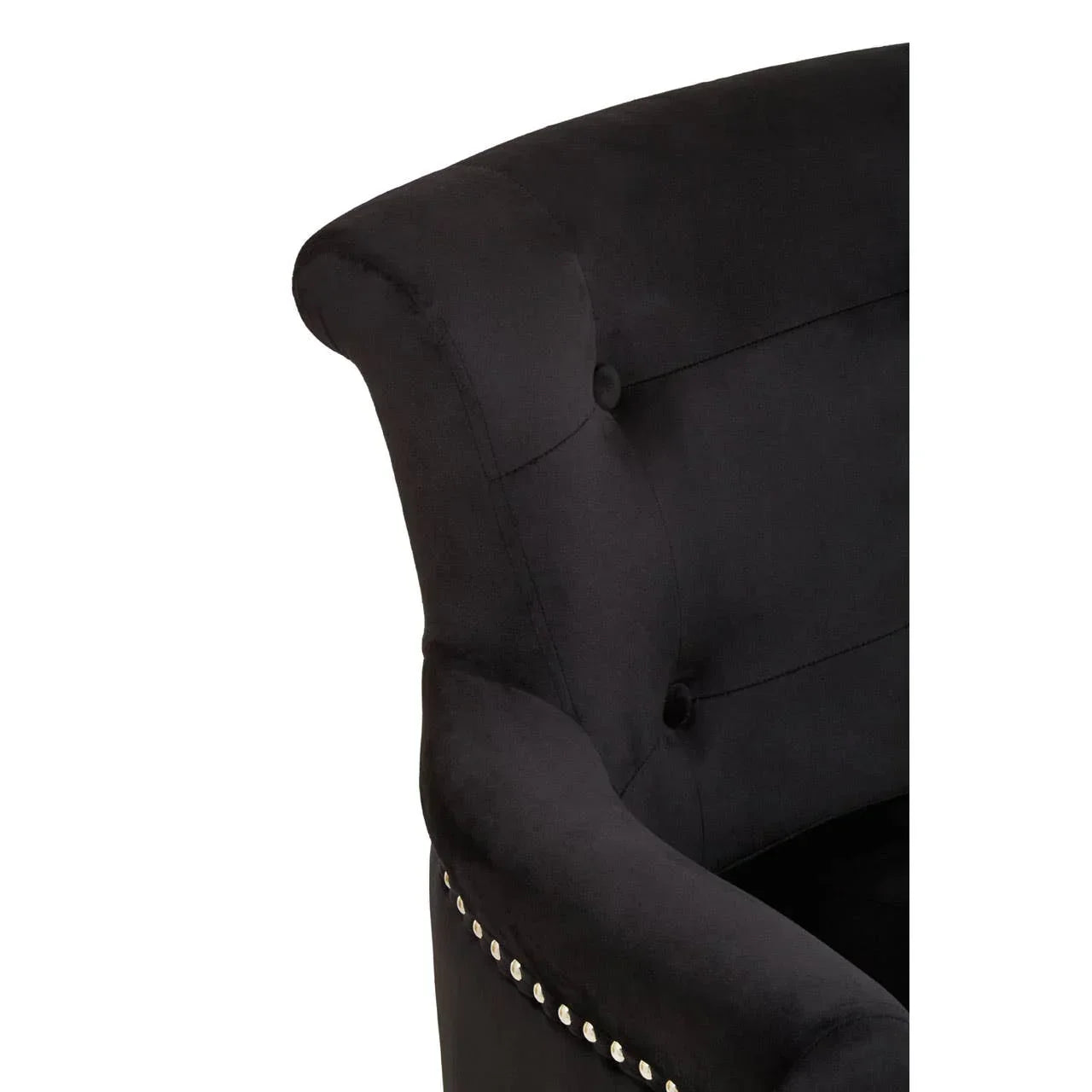 Closeup of black velvet armchair with tufted backrest and silver studded trim