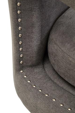 Grey fabric armchair with silver studded trim closeup