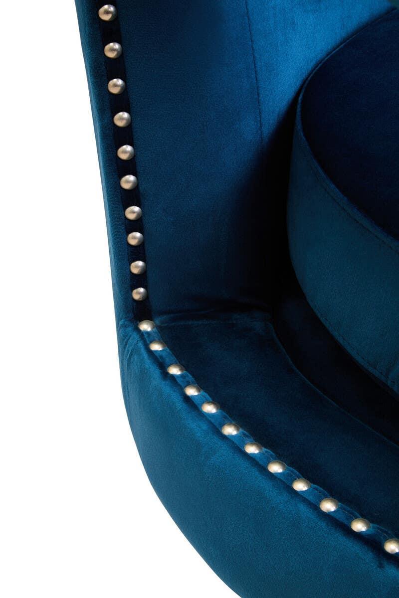 Blue velvet accent chair with silver stud detailing on armrest