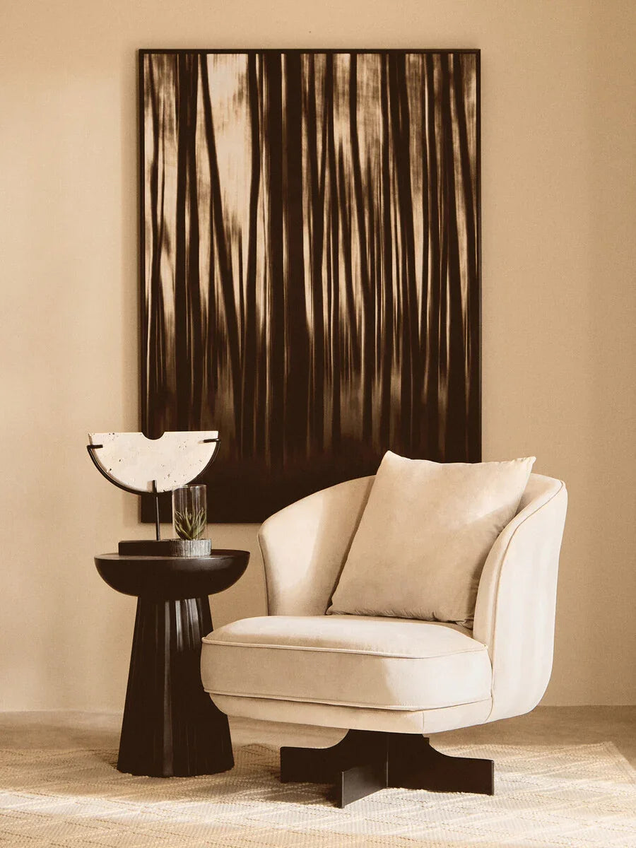 Cream accent chair with cushion beside black round side table in modern living room