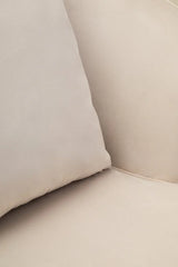 Beige fabric sofa seat with matching cushion close-up