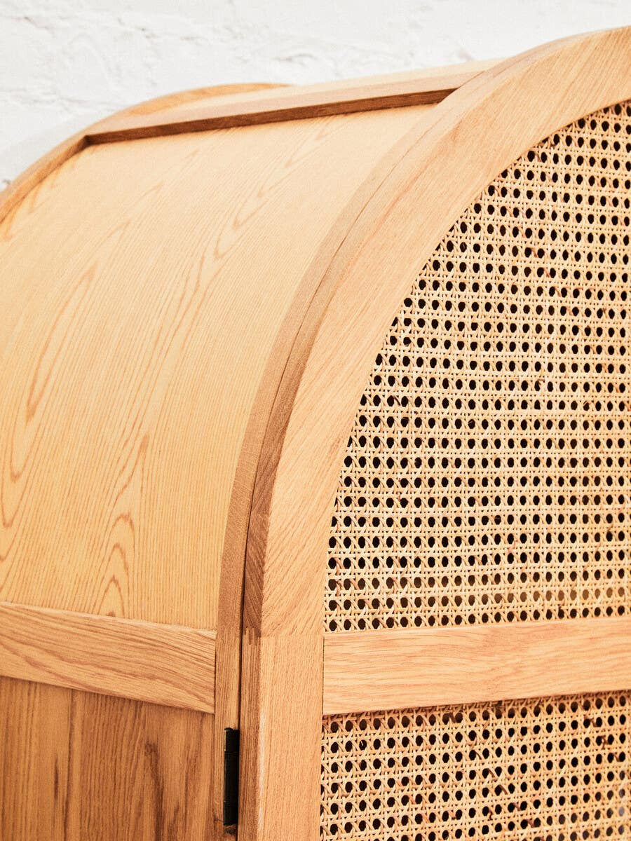 Close-up view of the Lyon Rattan and Oak Wood 2 Door Wardrobe, showcasing the curved top and woven rattan detailing on the doors, highlighting the natural wood grain and warm tones of the oak