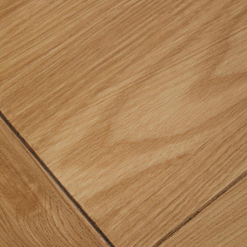 Close up of light oak wood table top with visible grain and joined edge