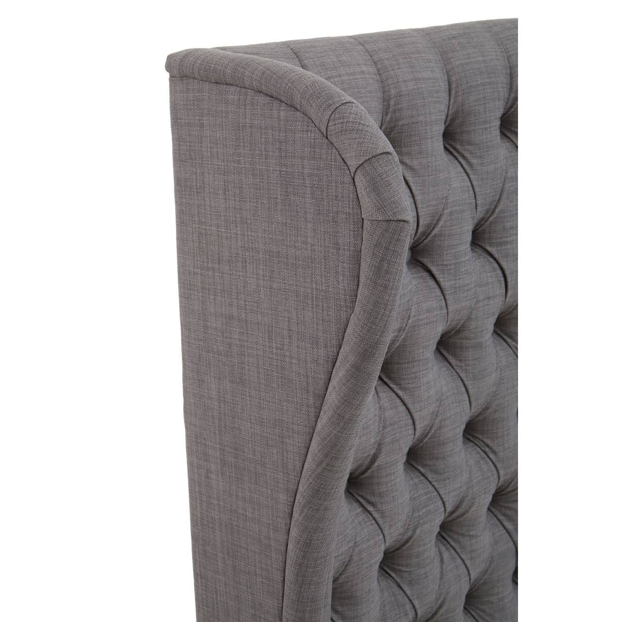 Grey kingsize headboard featuring a tufted design with a curved edge, showcasing a soft fabric texture