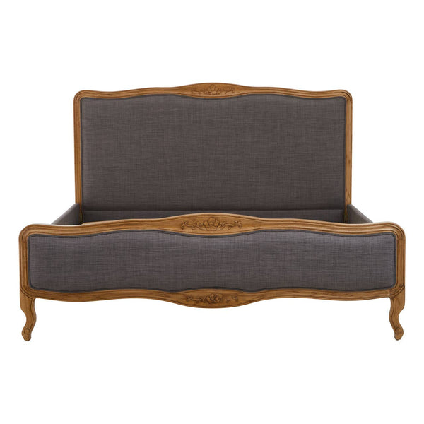 Grey fabric super kingsize bed with a curved wooden frame and ornate detailing on the headboard and footboard, featuring elegant legs