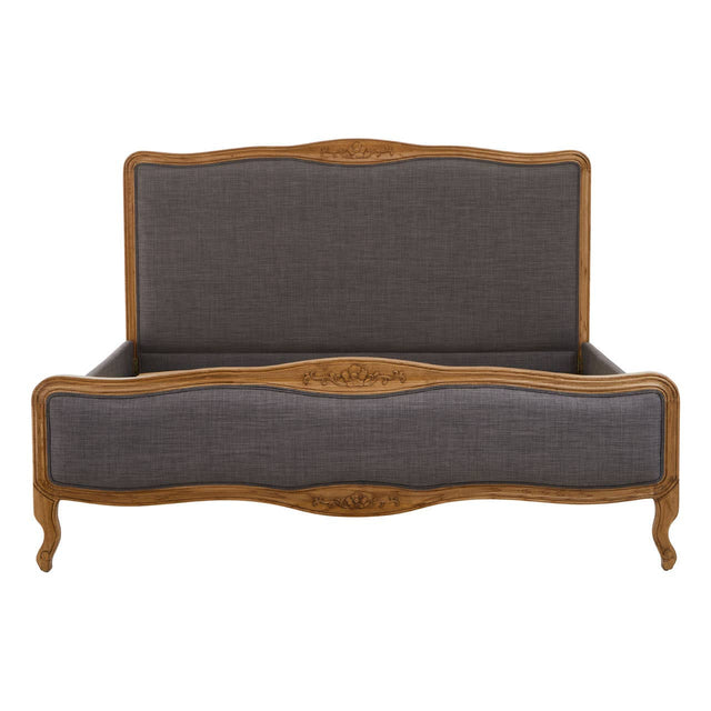 Grey fabric super kingsize bed with a curved wooden frame and ornate detailing on the headboard and footboard, featuring elegant legs