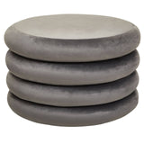 A stack of four round pouffes in a soft grey velvet fabric, featuring a smooth, plush surface and a minimalist design suitable for home decor
