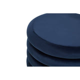 Midnight navy velvet round pouffe with a smooth, circular top and plush texture, stacked with additional pouffes in the background