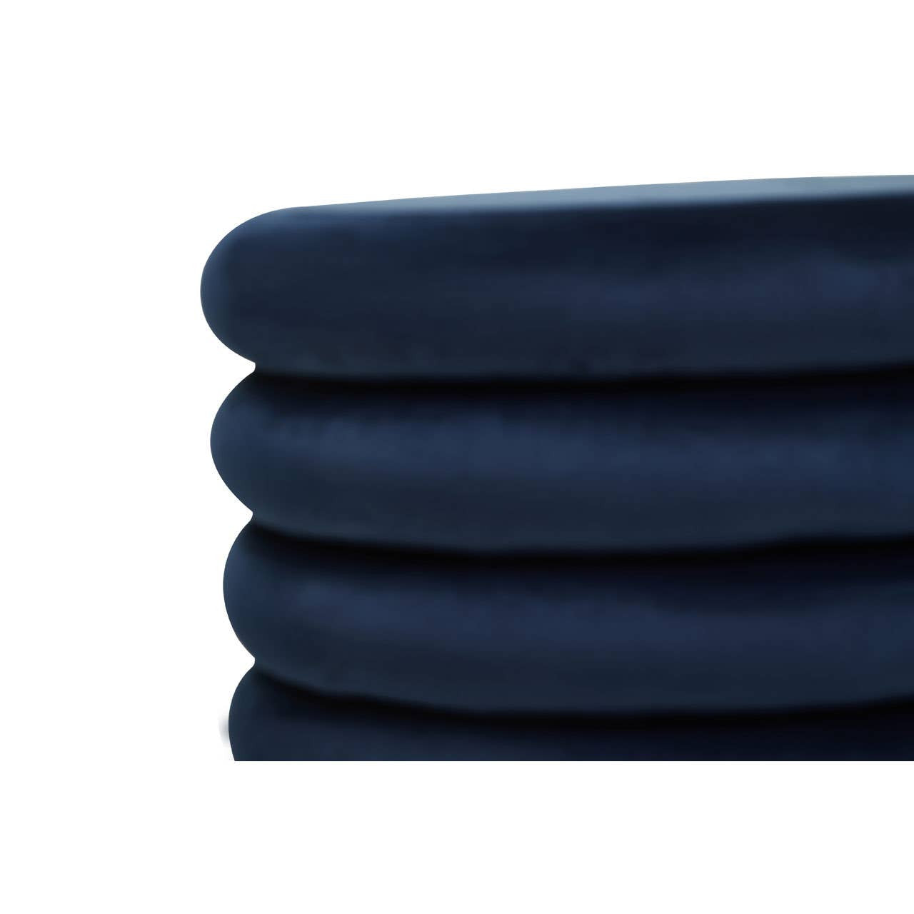 Midnight navy velvet round pouffe with a smooth, soft texture, featuring a stacked design that highlights its plush cushioning