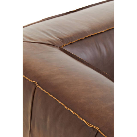 Close-up view of the corner of a King Two Seater Antique Brown Leather Sofa, showcasing the rich, textured brown leather and contrasting stitching along the edges. The sofa features a square, padded design with visible seams, emphasizing its vintage style and craftsmanship