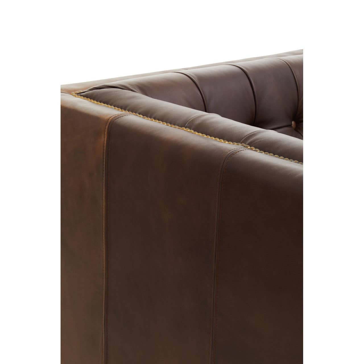 Close-up view of the corner of a dark brown leather Chesterfield sofa, showcasing the tufted design and smooth finish of the leather upholstery. The sofa features a modern silhouette with clean lines and a sturdy frame