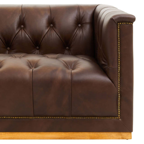 Dark brown leather Chesterfield sofa featuring a tufted design, elegant gold trim along the edges, and a sturdy wooden base. The sofa has a modern aesthetic with a three-seater capacity and plush cushioning for comfort