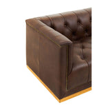 Dark brown leather corner of a modern Chesterfield sofa featuring tufted upholstery and a sleek design, with a wooden base visible at the bottom