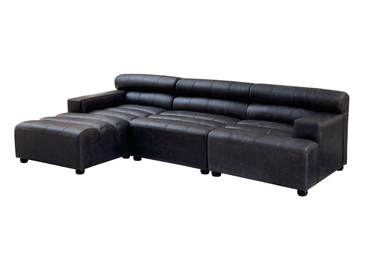 Antique black leather modular sofa chair with a sleek design, featuring no armrests and a low backrest. The sofa has a sectional layout with a chaise lounge on one side, supported by short, sturdy legs. The leather upholstery has a smooth finish, showcasing a modern yet classic aesthetic suitable for various interior styles
