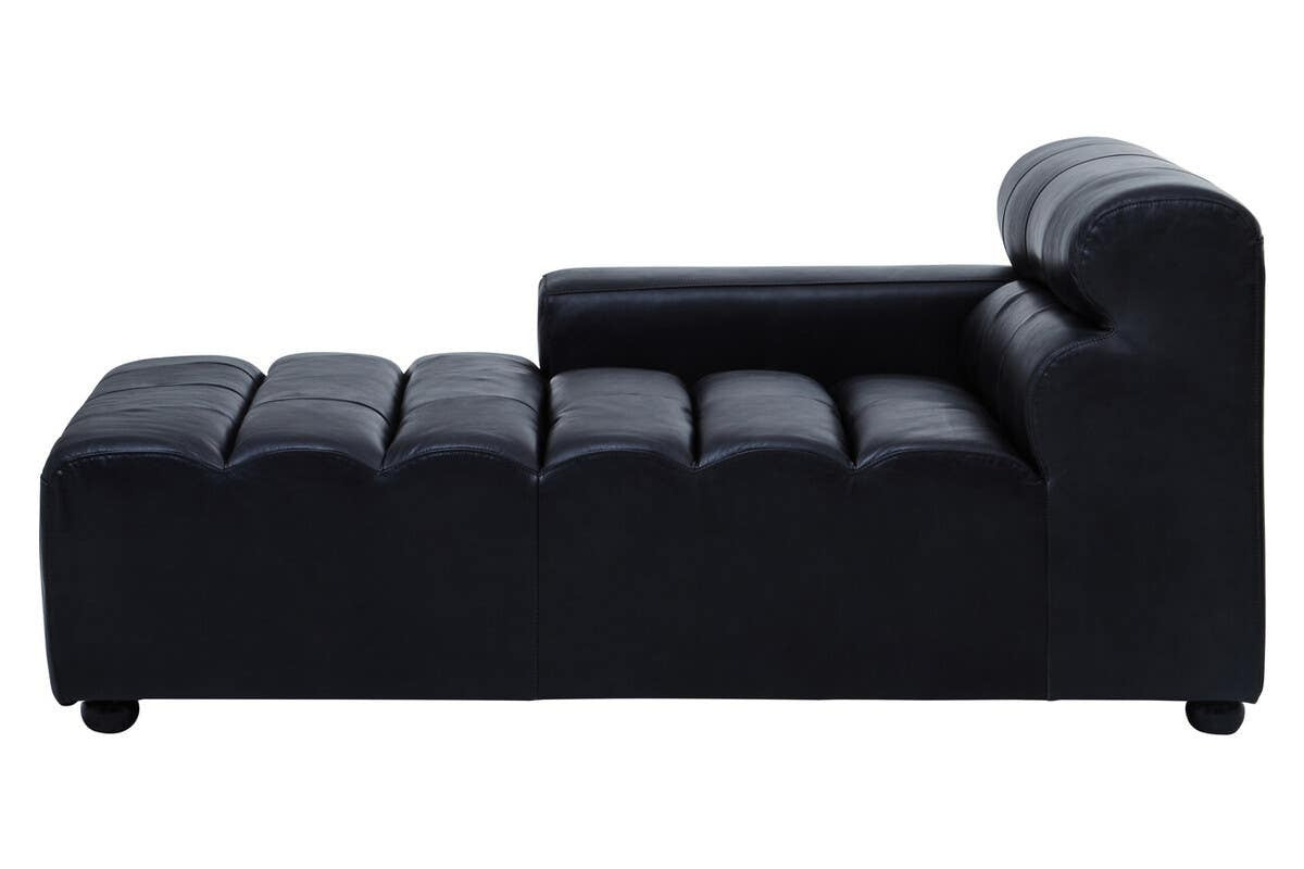 Left arm chaise sofa in antique black leather with a sleek, modern design. The sofa features a low backrest and a series of horizontal tufted sections along the seating area. The legs are short and rounded, providing stability and a contemporary look