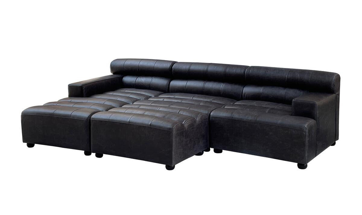 Left arm modular chaise sofa in antique black leather, featuring a sleek design with a low backrest and plush seating. The sofa has a sectional layout with a spacious chaise, supported by short legs for stability. The leather upholstery showcases a smooth finish, enhancing its modern aesthetic