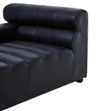 Left arm of a modular chaise sofa upholstered in antique black leather, featuring a tufted design on the seat and a rounded backrest for added comfort. The sofa has a sleek, modern appearance with a low profile and sturdy base