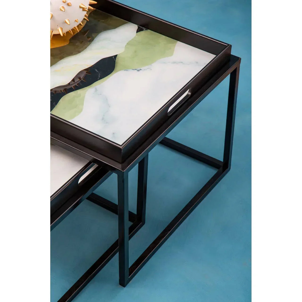 Modern nesting coffee tables with abstract marble tops and black metal frames