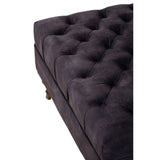 Dark grey tufted fabric ottoman with wooden feet, close-up of cushioned top
