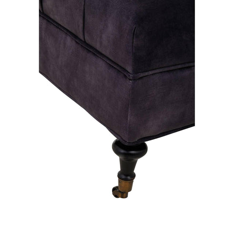 Close-up of dark fabric sofa corner with turned wooden leg and caster