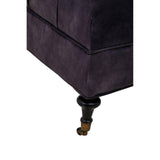 Close-up of dark fabric sofa corner with turned wooden leg and caster