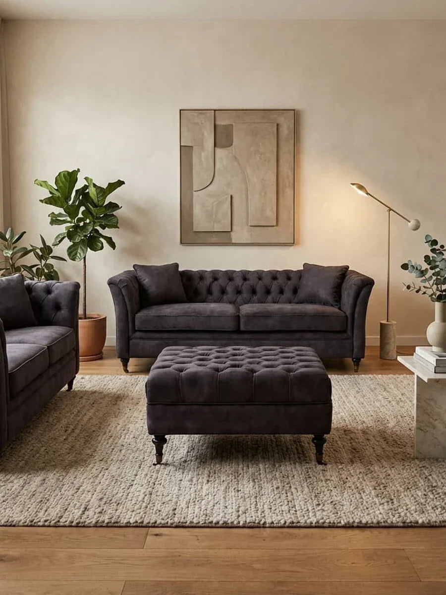 Dark grey velvet sofa set with matching ottoman on textured rug in modern living room