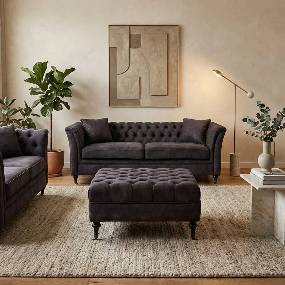 Dark grey velvet sofa set with matching ottoman in modern living room with decor accents