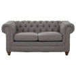 Two-seat sofa upholstered in grey linen with a tufted backrest and rolled arms, featuring wooden legs. The cushions are plush and inviting, designed for comfort and style